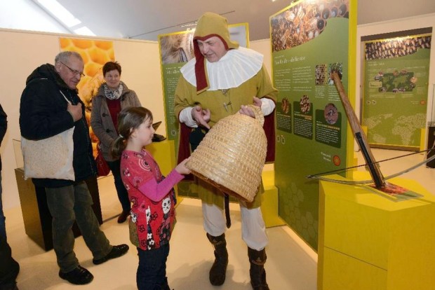 Begegnung mit altem Handwerk: Kelly Beerbaum bekommt von Holger Ackermann einen Bienenkorb gezeigt. Ackermann kam in der Kluft eines Zeidlers zur Ausstellung. Zeideln bedeutete früher, die Waben aus Bäumen zu schneiden. © Foto: Sergej Scheibe