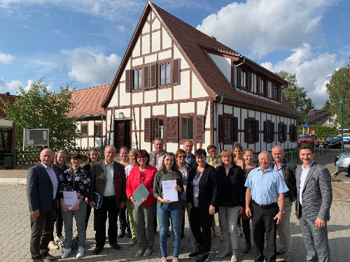 Vertreter aus den Städten und Gemeinden der Dübener Heide, des Vereis Dübener Heide und der Agentur commlab posieren anlässlich der Vorstellung des Standortmarketingskonzeptes für ein gemeinsames Gruppenfoto vor dem Bürgerhaus in Görschlitz (Gemeinde Laußig). Foto: Verein Dübener Heide e.V.