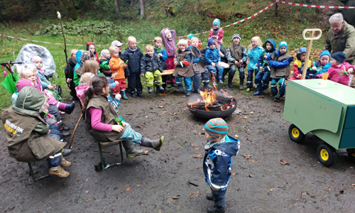 Die Kinder des Familienzentrums Lennetal beim gemütlichen Lagerfeuer - rechts im Bild: das mobile Waldlabor des Naturparks Sauerland Rothaargebirge (Foto: Familienzentrum Lennetal)