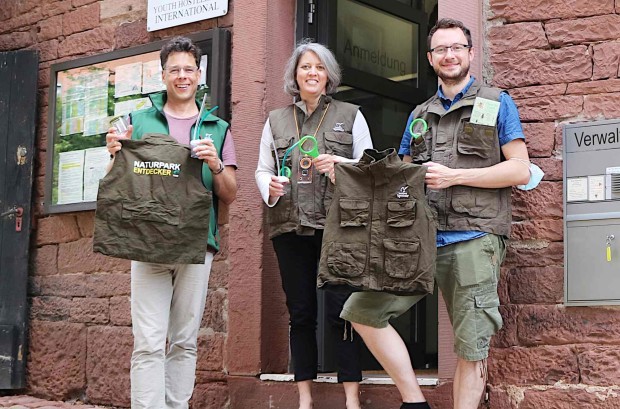 Oliver Kaiser übergibt der wirtschaftlichen Leiterin der Burg Susanne Stöhr und Phillip Fuhrman 16 Entdeckerwesten des Naturparks Spessart