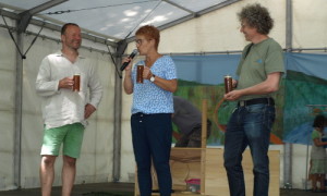 Gemeinsam mit Carla Kniestedt präsentieren Henning Storch (l) und Naturparkleiter Mario Schrumpf den "Roten Hahn" auf der Waldfestbühne.