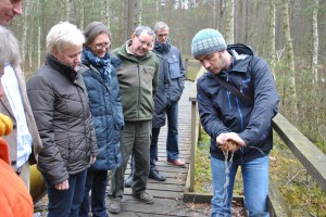 Projektleiter Michael Zauft erklärt Staatssekretärin Dr. Carolin Schilde die Wasserspeicherfähigkeit von Torfmoosen.