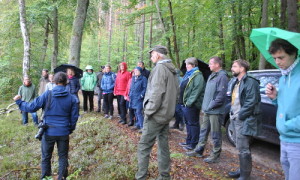 Michael Zauft beschreibt bei strömendem Regen aber geduldigen Zuhörer*innen Wiedervernässungsmaßnahmen von Waldmooren