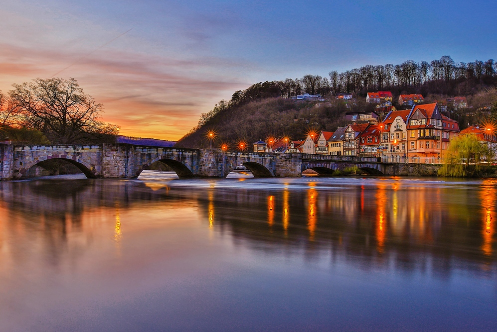 Titelmotiv der Reisebroschüre - Fluss mit Fachwerkhäusern im Naturpark Münden