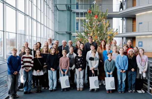 Bundestagsvizepräsident Omid Nouripour, Bündnis 90/Die Grünen, MdB, nimmt den Weihnachtsbaum des Naturparks Barnim entgegen. Gruppenfoto mit der Naturpark-Schule Schönow aus dem Naturpark Barnim Weihnachten im Paul-Löbe-Haus, Berlin. © Deutscher Bundestag/Anika Nowak